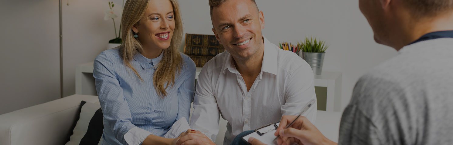 Woman and man smiling and looking at the person in front of them