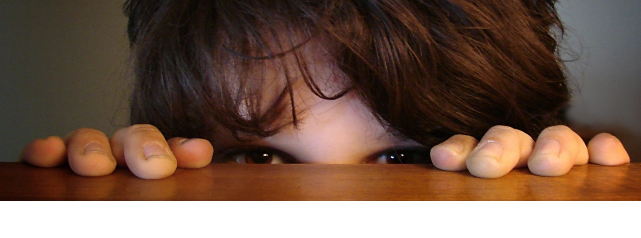 A little boy who is trying to hide. In the picture only visible his forehead and eyes 